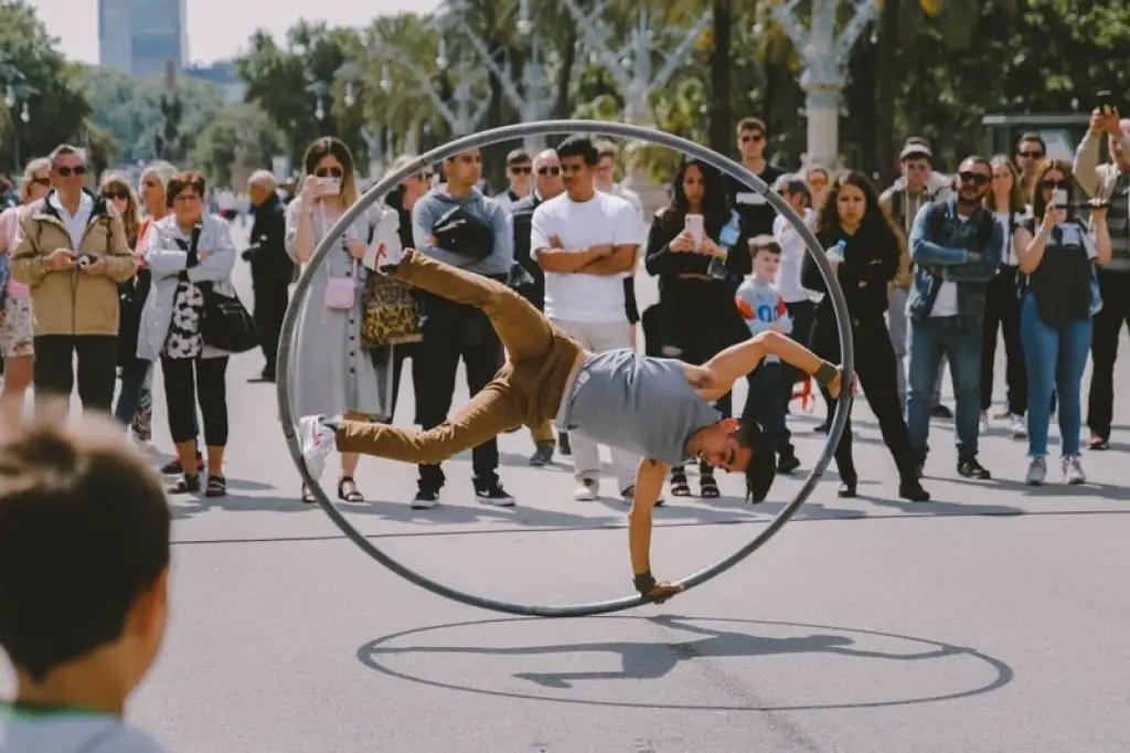 street-artist-performing-stunt-with-big-hula-hoop-with-a-crowd-watching